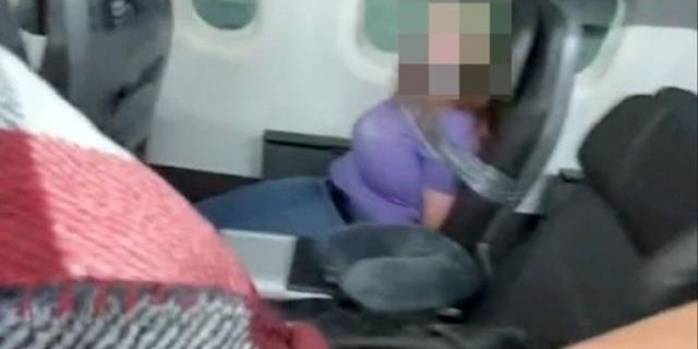 Uçağın kapısını açmaya çalışan kadını, koli bandıyla bağladılar